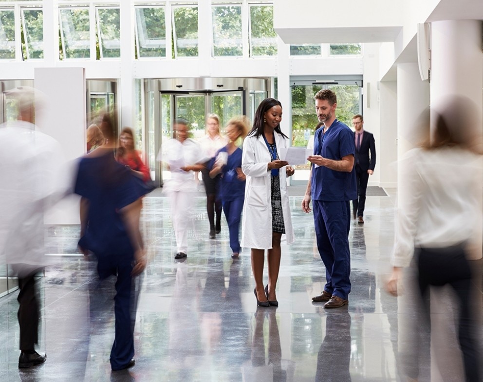 Healthcare leadership team walking through a hospital corridor, representing experienced managed care oversight, collaboration, and performance-driven healthcare administration.